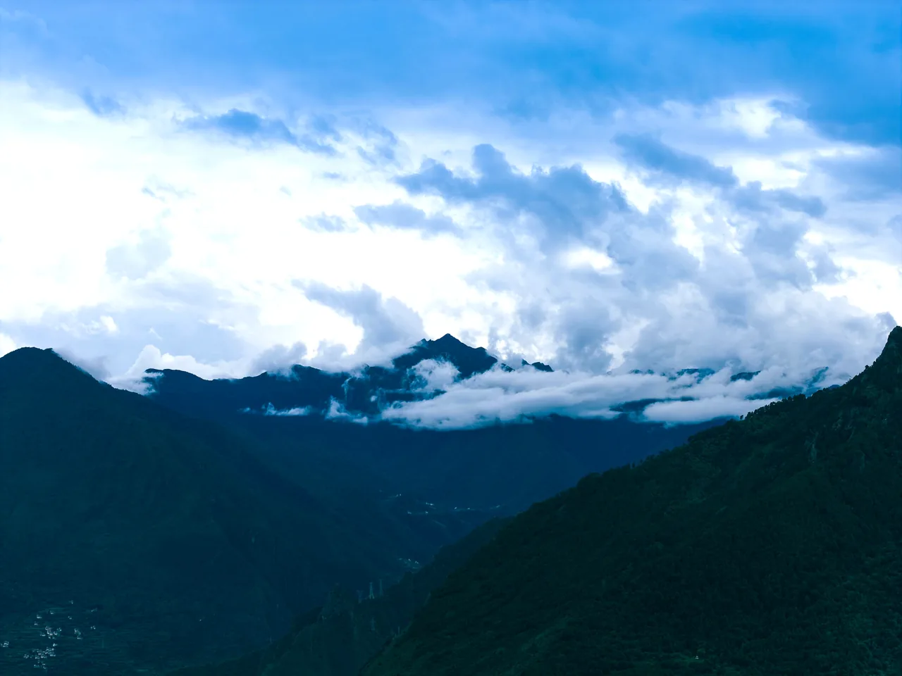 Sichuan mountain landscape · regional setting, not a photograph of Jiuzhaigou or Huanglong. Destination context; the selected programme confirms included visits.