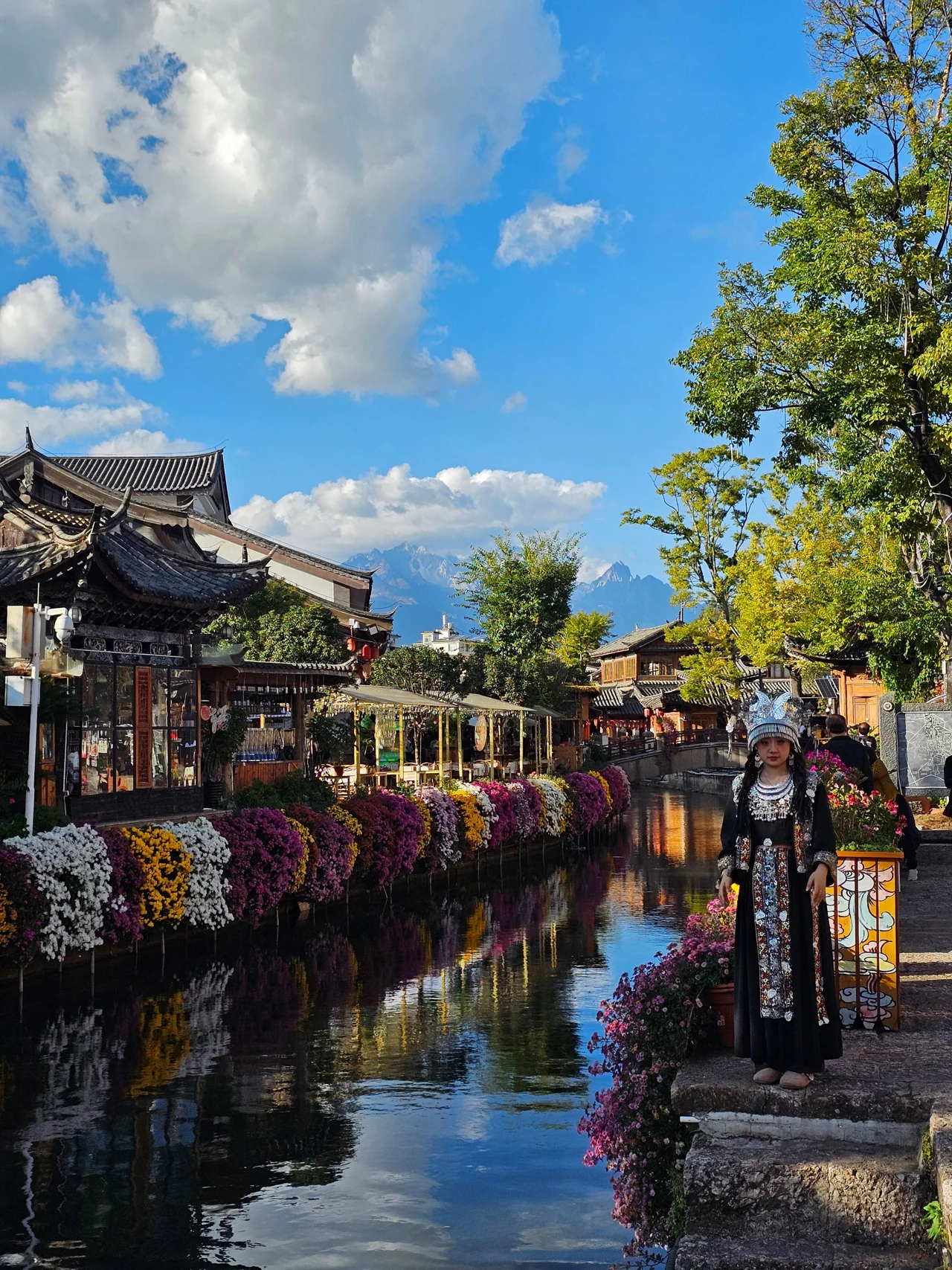 Traditional architecture and a flower-lined canal in Lijiang, Yunnan. Destination context; confirmed itinerary determines visits.